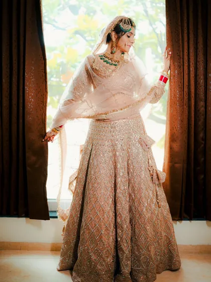 A full length portrait of a beautiful Sikh bride in a pastel lehenga, captured in natural light to showcase her elegance and the flow of her outfit.