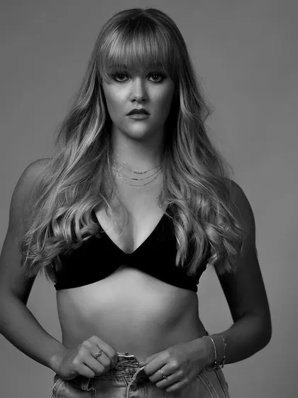 A beautiful black and white portrait of a model in a bra top and jeans, with a focus on clean lines and a soft, yet confident expression.