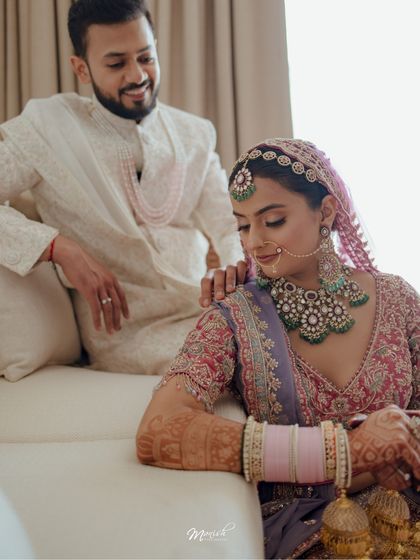 A tender moment between the bride and groom, his hand on her shoulder, her gaze soft and content.