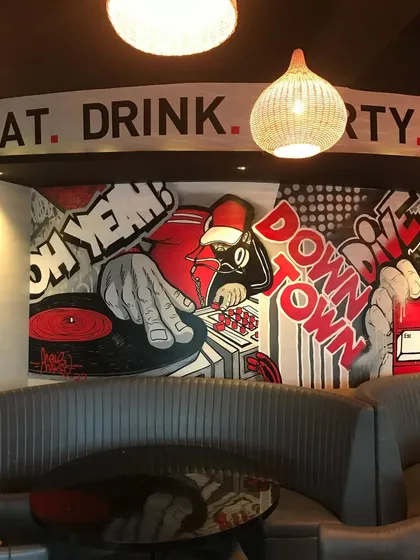 I brought a pop-art, comic book vibe to this downtown restobar. This mural section features a DJ spinning vinyl, setting the energetic tone for the whole space with bold red and black graphics. It’s all about creating an atmosphere that makes people want to stay.