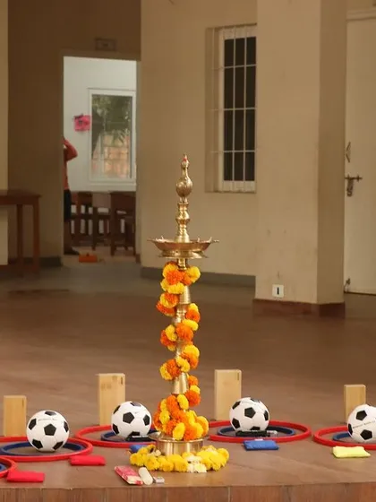 A beautiful setup for the kickoff of our Montessori Sports course, with a traditional lamp surrounded by sports equipment, symbolizing the blend of philosophy and practice.