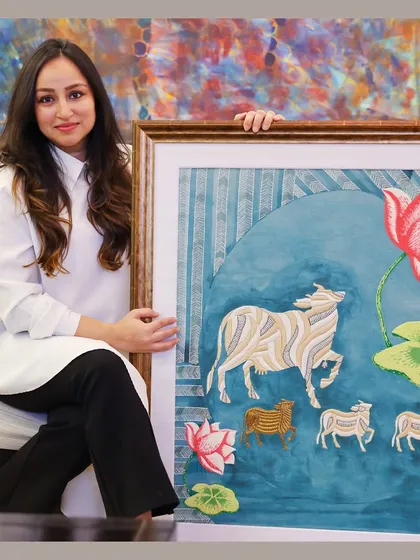 My heritage is my greatest inspiration. Here I am with a piece from my Heritage Collection, a modern interpretation of traditional Pichwai art. This hand-embroidered artwork, featuring the sacred Nandi, connects my roots in Rajasthan with my contemporary artistic practice.