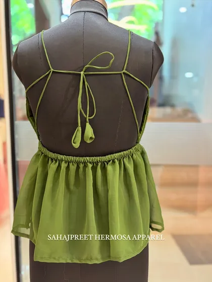 The back of our olive green PEECHA kurti, featuring a criss-cross strap design with cute tassels.