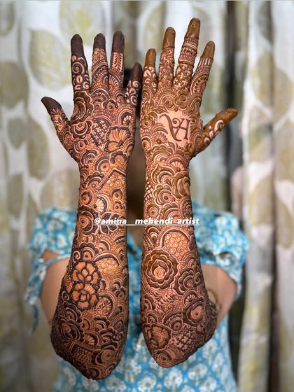 This design features the initial 'A' on one palm, surrounded by a beautiful mix of floral and paisley patterns.