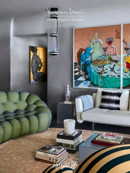 The living room features a mix of iconic pieces, including a green bubble couch and a classic white sofa. The space is anchored by a large, surreal art piece that sparks conversation.
