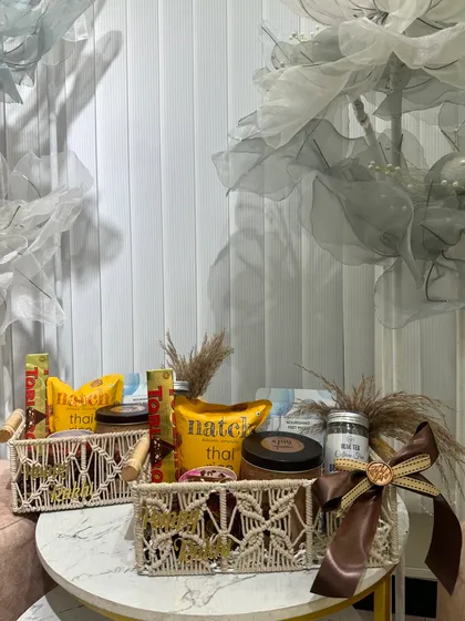 A sophisticated Rakhi hamper in a macrame basket. This one has a neutral, earthy theme with a focus on gourmet snacks and coffee.