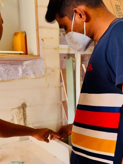 A close-up of a discussion with a carpenter about the fine details of a furniture piece.