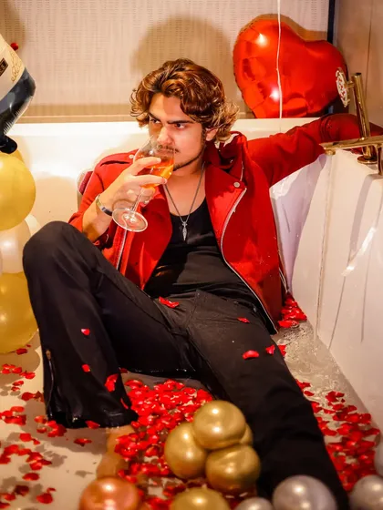 A candid moment from the bathtub shoot, capturing the model taking a sip of the drink.