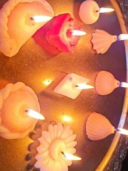 A beautiful, warm-toned image of lit mithai candles. The variety of shapes, from Gujiya to Shankh, demonstrates the creative possibilities for festive decorations.