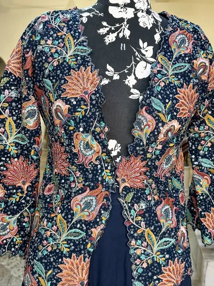 The jacket has a beautiful scalloped edge, adding a delicate touch to the bold print.