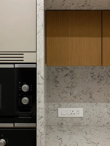 This detailed shot highlights the precise integration of the oven and the surrounding cabinetry. The combination of the textured quartz, the warm wood, and the clean lines of the appliance demonstrates a commitment to both beauty and function.