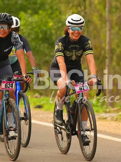 Two female riders, smiling and enjoying the race.