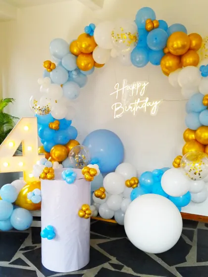 Turning four is a big deal, and we made sure this celebration was picture perfect. We designed this beautiful circular balloon arch with a soft blue, white, and gold palette, complete with a custom neon sign and marquee number, creating a magical photo corner for the little one.