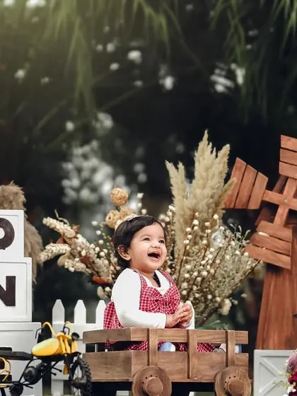 This rustic outdoor setup is perfect for a little adventurer's first birthday. The wooden props and natural light create a warm and inviting atmosphere for photos.