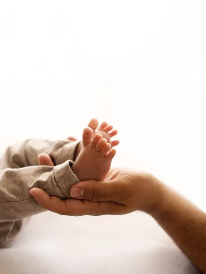 A father's hands cradling his baby's perfect little feet. I call these marshmallow feet, and they are just irresistible.