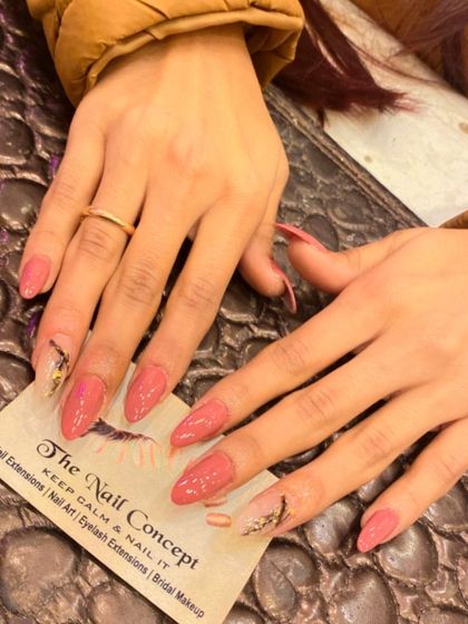 A beautiful set of long, stiletto nails in a dusty rose color. The accent nails feature a sheer base with an abstract design made from black lines and gold foil.