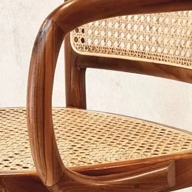 The junction of a curved armrest and a caned seat. Every detail is meticulously crafted to ensure both beauty and longevity.