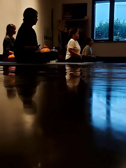 A silhouette of our meditation class, with the reflections on the floor adding to the serene and contemplative mood.