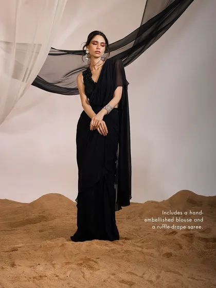 The Eve Saree Set in classic black, featuring a hand-embellished blouse and a modern ruffle-drape saree for a fashion-forward statement.