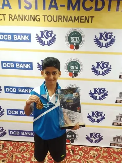 Aakarshan Yadav, our U-11 Boys champion, proudly displays his trophy and medal at the TSTTA-MCDTTA district tournament. We focus on building a strong foundation from a young age.