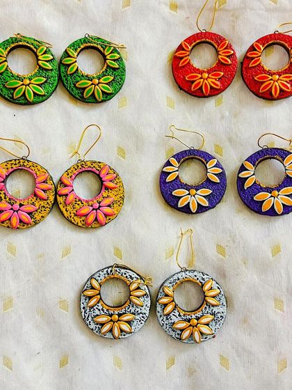 These are my floral hoop-style earrings. They are lightweight, colorful, and come in a variety of color combinations like green, red, purple, and yellow.