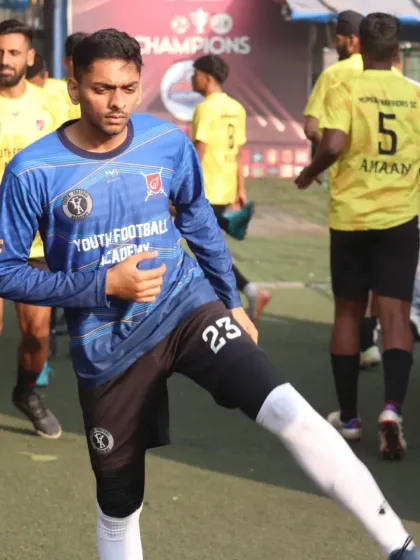 A player in our blue goalkeeper kit warms up before a crucial match, stretching and preparing to defend our goal.