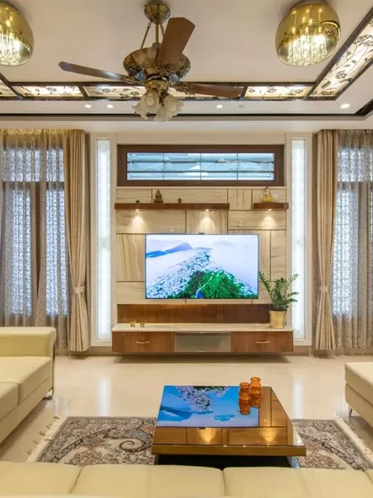 A frontal view of the TV unit, highlighting the natural texture of the travertine stone and the warm, ambient lighting.