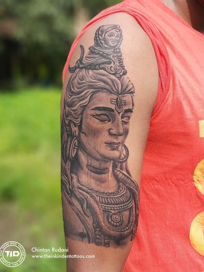 A realistic portrait of Adiyogi Shiva on the upper arm. The detailed shading captures the meditative and powerful presence of the first yogi, creating a piece that inspires inner stillness.