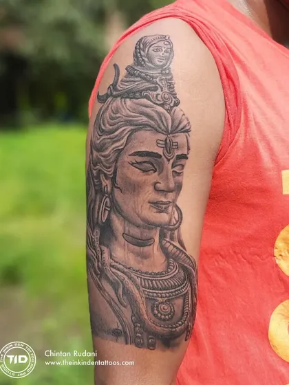 A realistic portrait of Adiyogi Shiva on the upper arm. The detailed shading captures the meditative and powerful presence of the first yogi, creating a piece that inspires inner stillness.