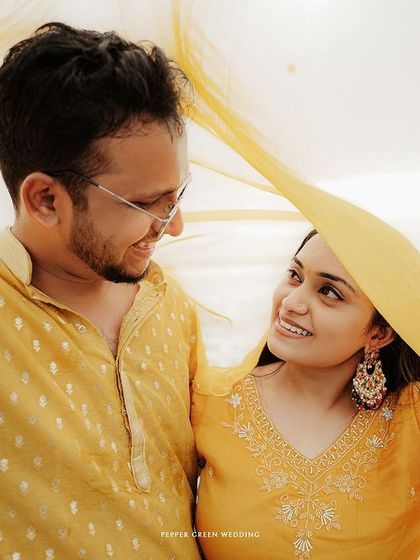 A playful moment under a dupatta, this pre-wedding photo is filled with laughter and light.