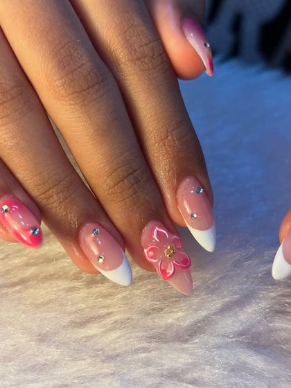 The perfect holiday nails. This set combines a classic white French tip with a pop of bright pink and 3D pink flowers. The scattered rhinestones add just the right amount of sparkle for a fun, feminine look.