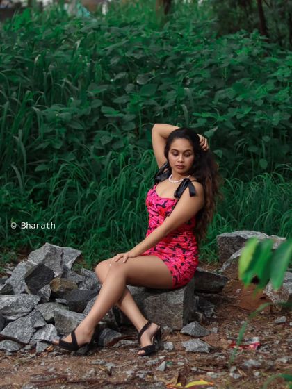 A classic portrait pose set against a lush, green background. The natural setting adds a serene and timeless quality.