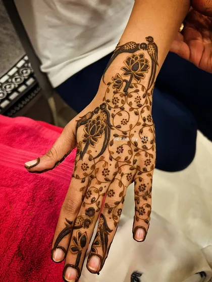 A delicate and artistic design with birds and vines, creating a beautiful wrap-around effect on the hand.