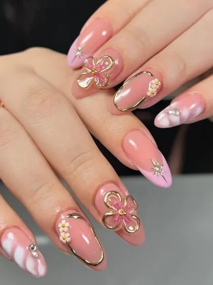 When your nails are the real showstoppers. This set features sculpted pink petals framed in gold, creating a stunning 3D floral design that is both glamorous and artistic.