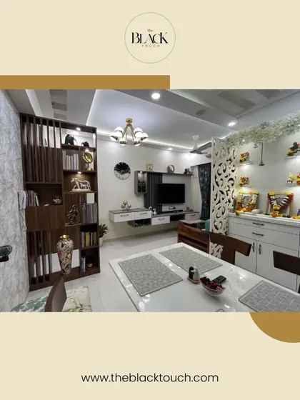 This dining and living area is designed for both function and style. The space includes a bookshelf partition, a dedicated mandir, and a comfortable seating arrangement, all tied together with a cohesive design.