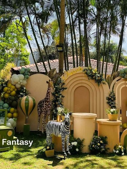 A full view of the modern safari setup for Charvik's first birthday. This image shows the scale of the outdoor decoration, including a safari jeep prop, balloon arches, and the main backdrop with animal figures.