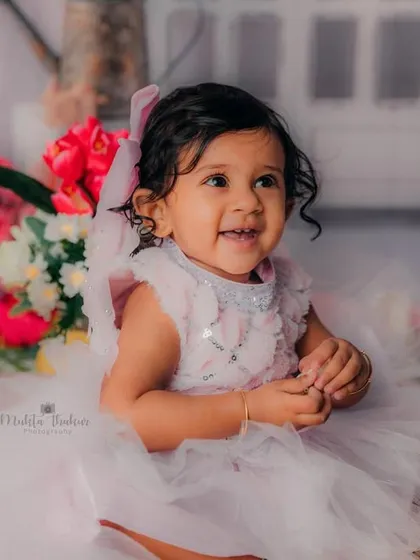 A smile that could light up any room. This happy one-year-old loved her floral-themed birthday celebration.