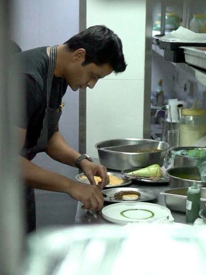 Another view of me plating, seen through a kitchen pass-through window.