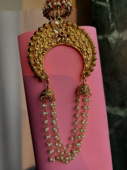 A close-up shot of the 'Khopa' against a pink background, highlighting the stone work.