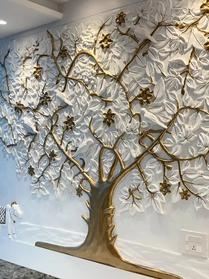 A side view of the Kalpavriksha mural, showing its 3D quality and how it interacts with the natural light from the large office window.