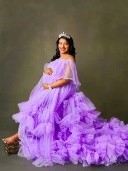 Feel like a true princess in this off-the-shoulder lavender tulle gown. The soft ruffles and expansive train create a dreamy and elegant look.