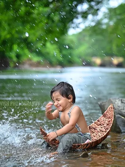 A joyful action shot of the baby splashing water, capturing pure, uninhibited fun.