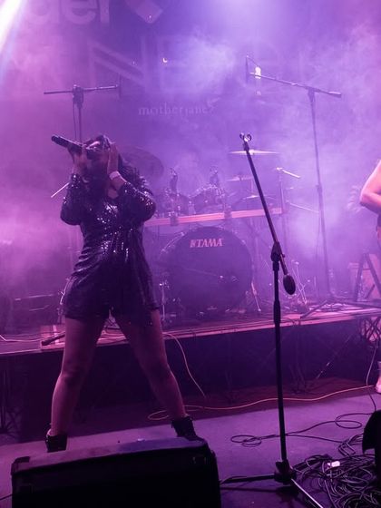 A dramatic shot from our opening act for the legendary band Motherjane. The stage lights and smoke create a powerful atmosphere, highlighting the intensity of our performance.