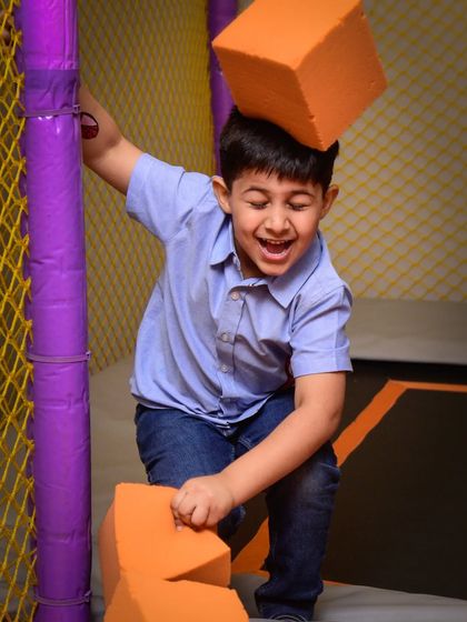 Having a blast while playing with the soft foam blocks on the trampoline. The laughter is contagious!