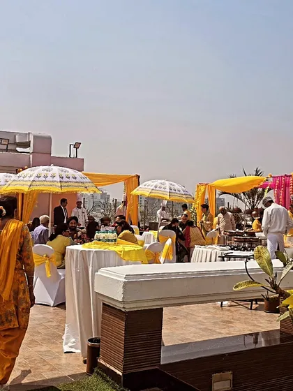 We create a complete festive atmosphere for your haldi. This outdoor rooftop event features a yellow color theme, guest seating, and large decorative umbrellas to provide shade and style.