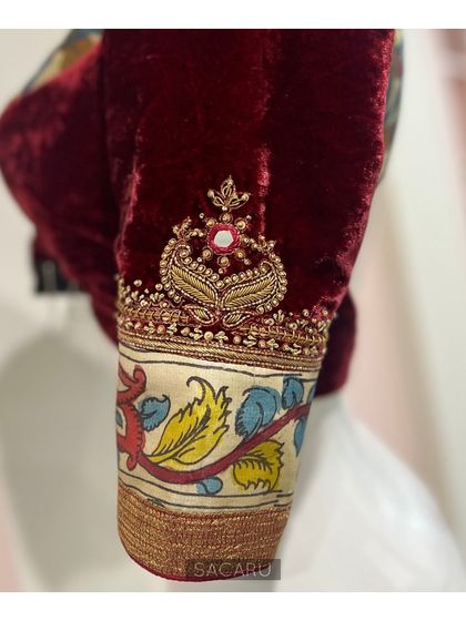 A close-up of the sleeve, showing the delicate hand embroidery that complements the traditional Kalamkari print on this velvet blouse.