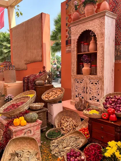An abundance of fresh vegetables, fruits, and spices arranged in baskets and on rustic furniture, creating a scene of a bustling, prosperous marketplace.
