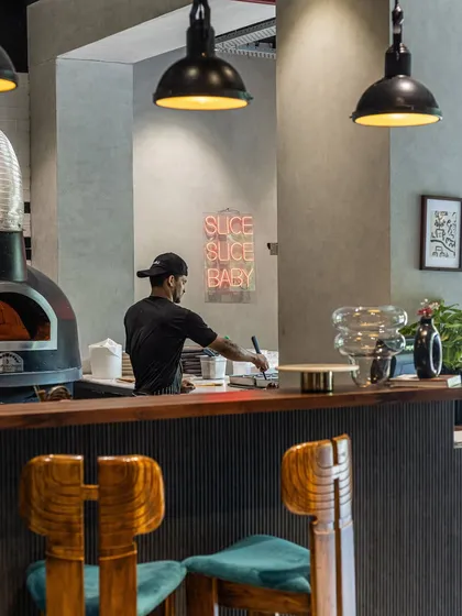 Here’s a glimpse of where the magic happens. My open kitchen, with the wood-fired oven at its heart and our pizzaiolo at work, is central to the chill, modern trattoria vibe. It’s a place to linger, watch the action, and feel like part of the family.