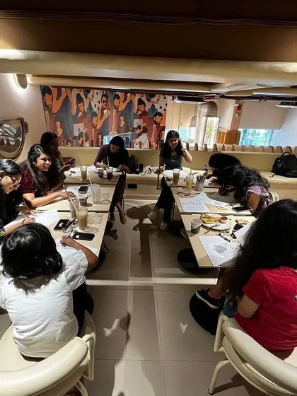 A wide shot of a workshop in progress at a cafe. The cozy ambiance, coffee, and art make for a perfect weekend activity.