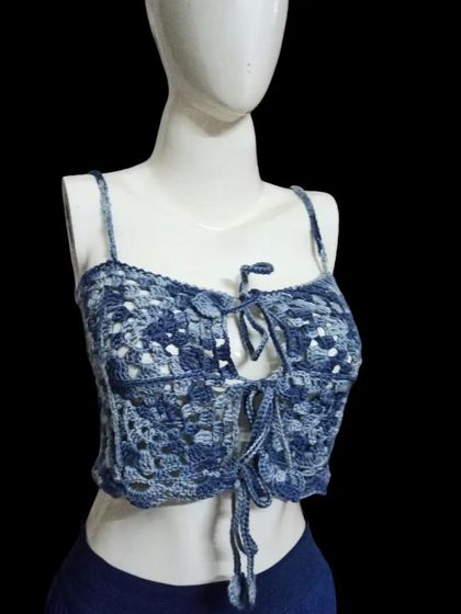 This bralette-style crop top in variegated blue yarn has a lovely tie-front detail. The open lacework makes it light and airy, perfect for beachwear or layering.